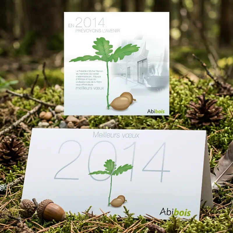 Carte de v&oelig;ux Abibois illustr&eacute;e d'une jeune pousse de ch&ecirc;ne et d'un gland pos&eacute;e en sous-bois