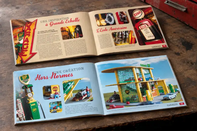 Maquettes ouvertes de deux livres illustr&eacute;s sur l'univers vintage des stations-services pos&eacute;es sur un &eacute;tabli en bois