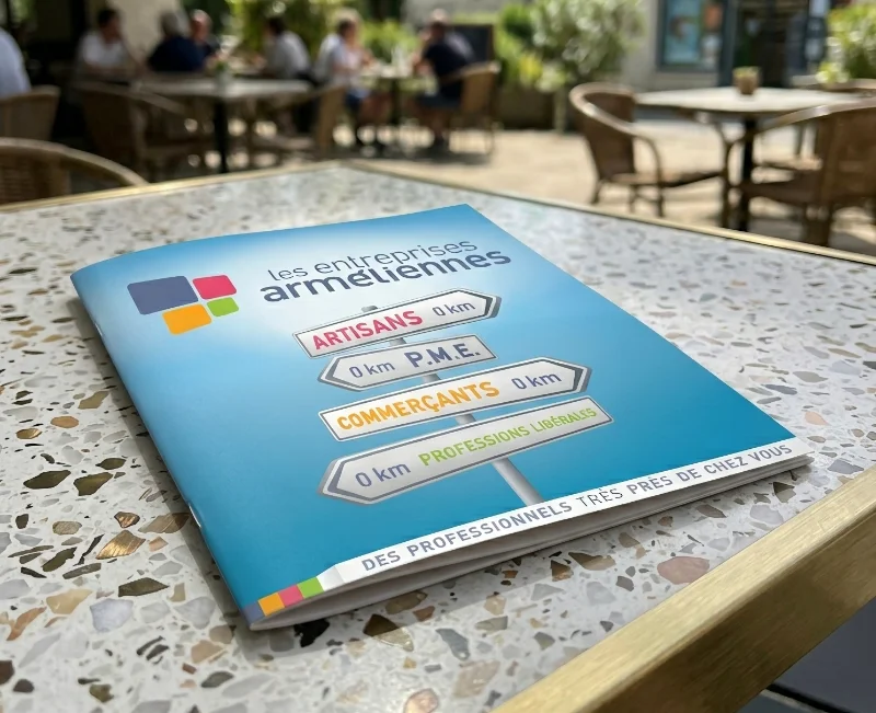 Plaquette imprim&eacute;e Les Entreprises Arm&eacute;liennes pos&eacute;e sur une table en terrasse